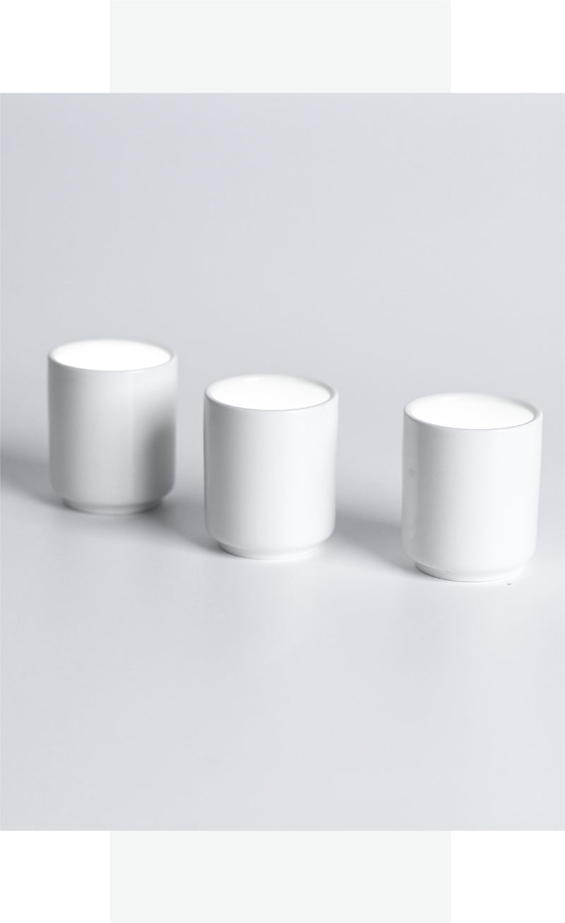 Three white cups on a light gray background